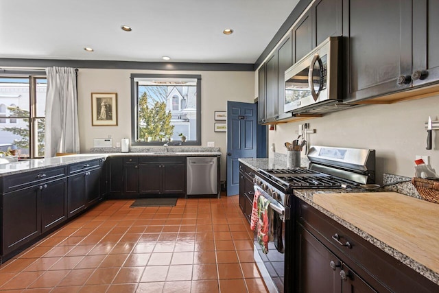 kitchen with light tile patterned flooring, appliances with stainless steel finishes, sink, and a wealth of natural light