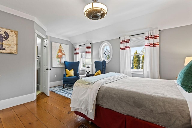 bedroom featuring multiple windows, hardwood / wood-style flooring, and vaulted ceiling