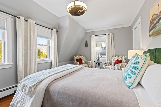 bedroom featuring multiple windows, hardwood / wood-style flooring, and baseboard heating