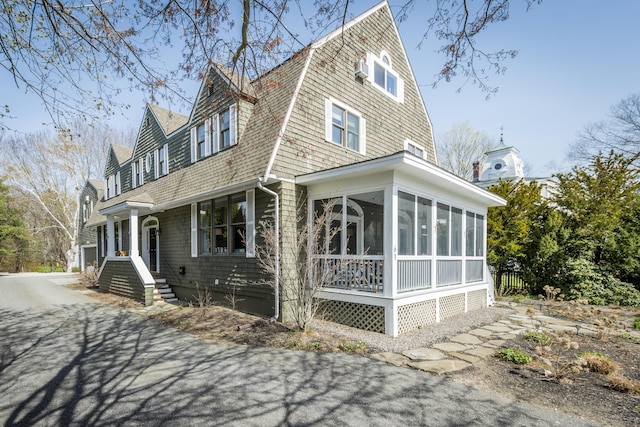 61 Fletcher St, Kennebunk, ME 04043 - view of front facade with roof with shingles, a sunroom, and a gambrel roof