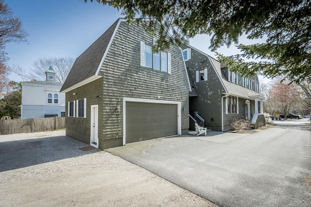 61 Fletcher St, Kennebunk, ME 04043 - view of side of property with a garage, a gambrel roof, driveway, and a shingled roof