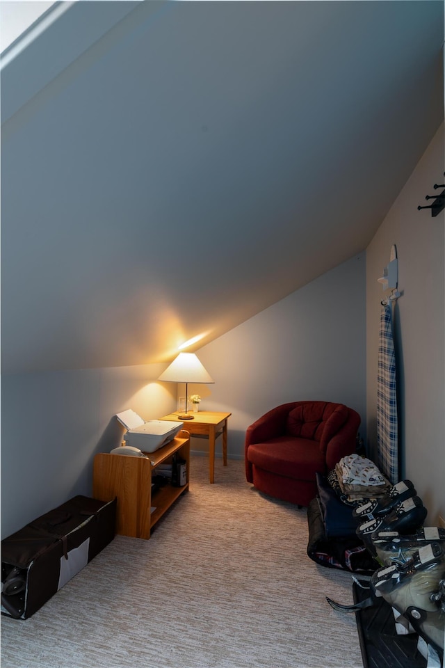 sitting room with vaulted ceiling and carpet floors