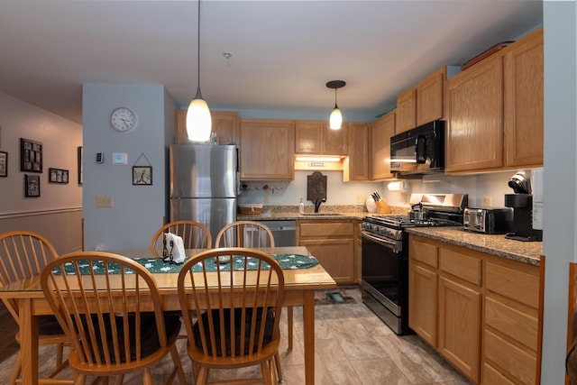 kitchen with hanging light fixtures, light stone countertops, appliances with stainless steel finishes, and sink