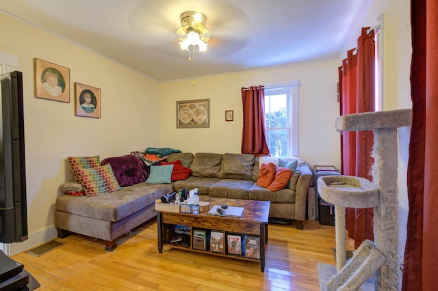 living room featuring crown molding, ceiling fan, and light hardwood / wood-style floors