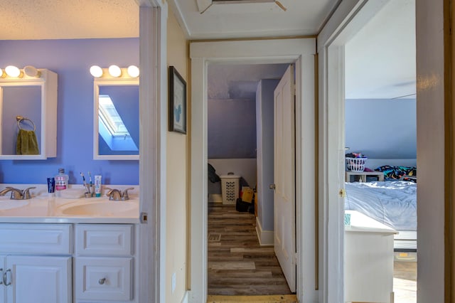 bathroom featuring hardwood / wood-style flooring, vanity, a skylight, and a textured ceiling