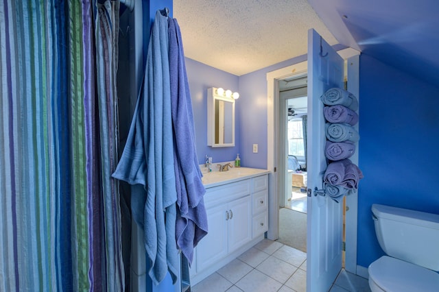 bathroom with vanity, toilet, tile patterned flooring, and a textured ceiling