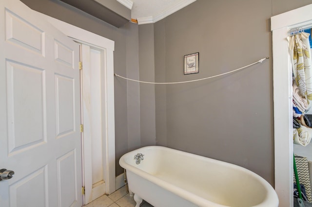 bathroom featuring ornamental molding, a tub to relax in, and tile patterned flooring