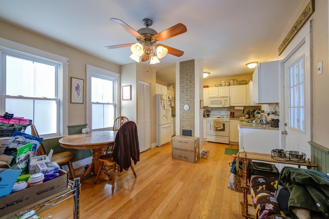 dining area featuring ceiling fan, a healthy amount of sunlight, and light wood-type flooring