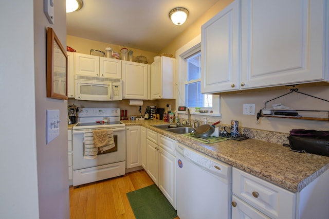 kitchen with sink, white appliances, light hardwood / wood-style floors, and white cabinets