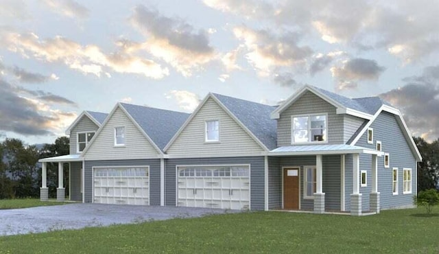 view of front of home with a lawn, covered porch, and a garage