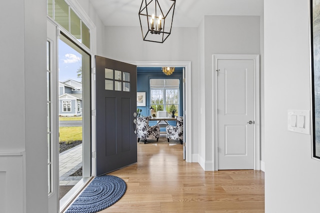 entryway with light hardwood / wood-style floors and an inviting chandelier