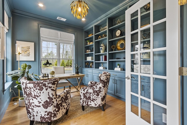 interior space with light wood-type flooring, ornamental molding, and built in features