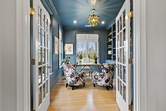 home office featuring light hardwood / wood-style floors, a chandelier, crown molding, and french doors