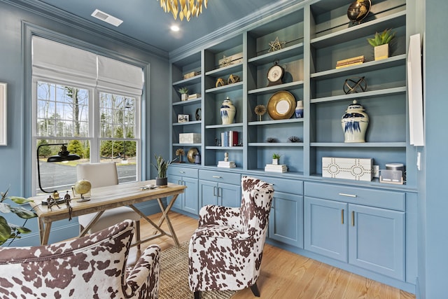 office with built in shelves, light hardwood / wood-style flooring, and ornamental molding