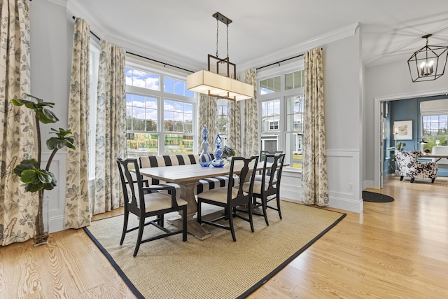 dining area featuring a notable chandelier, ornamental molding, and light hardwood / wood-style floors