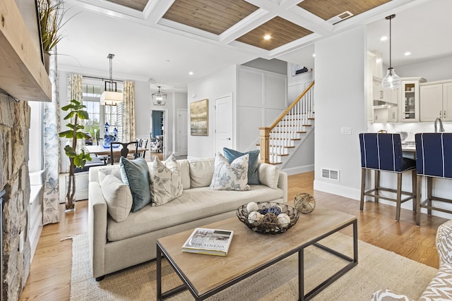 living room with light wood-type flooring, ornamental molding, beam ceiling, and coffered ceiling