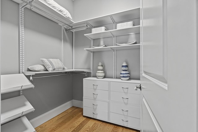 walk in closet with light hardwood / wood-style flooring