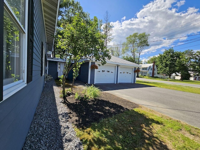 exterior space with a garage and an outbuilding