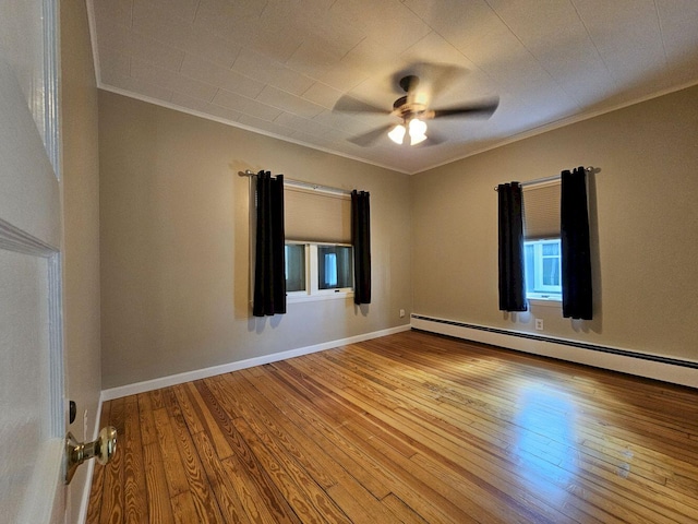 empty room featuring ceiling fan, a baseboard heating unit, ornamental molding, and light hardwood / wood-style flooring