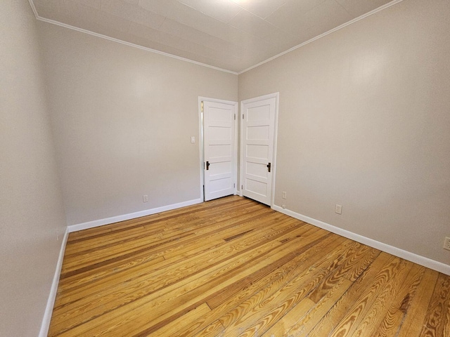 spare room featuring light wood-type flooring and ornamental molding