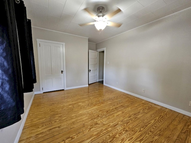 unfurnished bedroom featuring ceiling fan, crown molding, and light hardwood / wood-style flooring