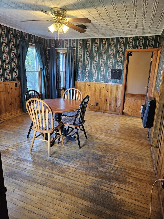 dining space with ceiling fan, heating unit, and wood-type flooring