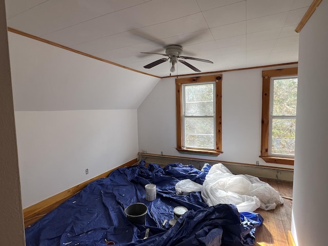 bedroom with ceiling fan, multiple windows, hardwood / wood-style flooring, and vaulted ceiling