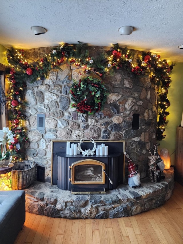 details featuring a textured ceiling, a fireplace, and wood-type flooring