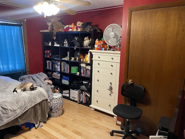 bedroom featuring a textured ceiling, ceiling fan, and hardwood / wood-style floors