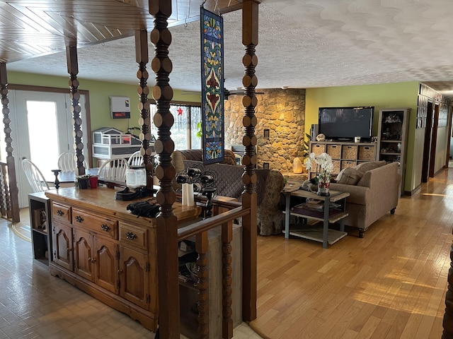 living room with light hardwood / wood-style floors, a textured ceiling, and a fireplace