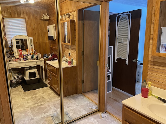 bathroom with vanity and wooden walls