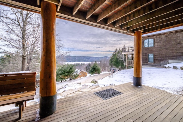 snow covered deck with a mountain view