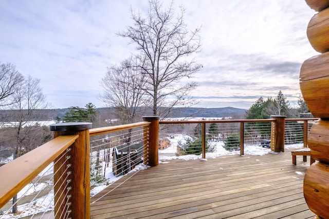 snow covered deck with a mountain view