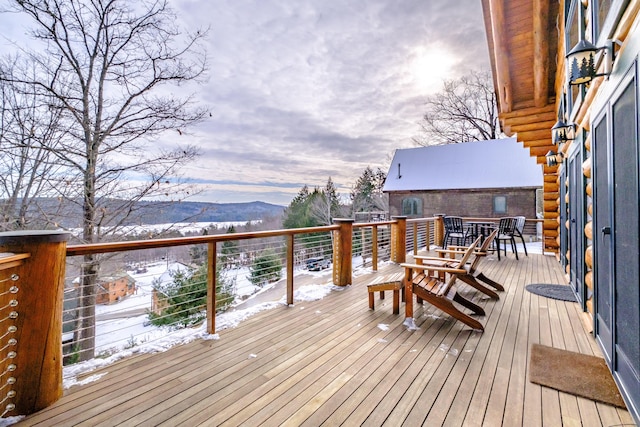 snow covered deck with a mountain view