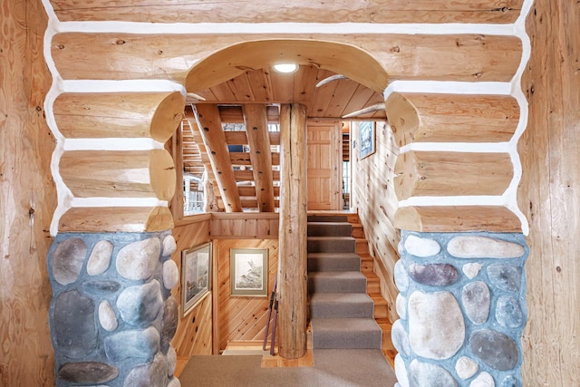 staircase with carpet flooring and wooden walls