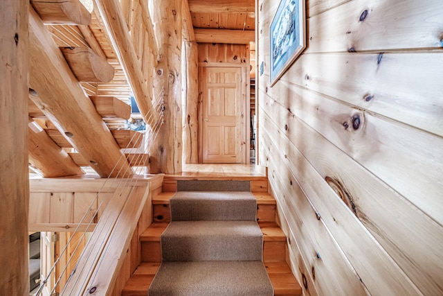 stairs featuring wood ceiling and wood walls