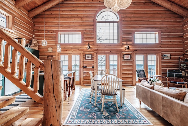 living room with rustic walls, french doors, and high vaulted ceiling