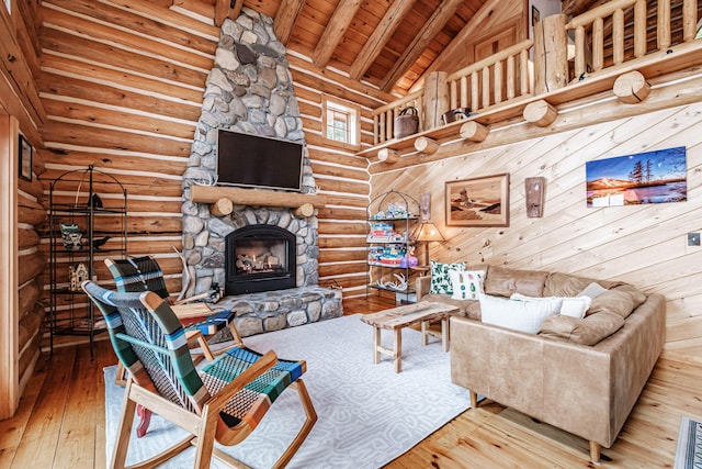 living room featuring wooden ceiling, a fireplace, wood-type flooring, high vaulted ceiling, and beamed ceiling