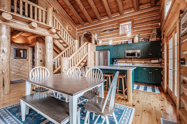 dining room featuring wood ceiling, light hardwood / wood-style floors, high vaulted ceiling, rustic walls, and beamed ceiling