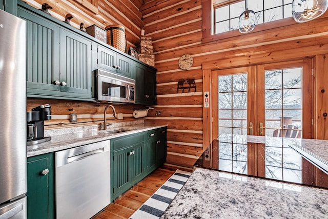 kitchen featuring light hardwood / wood-style floors, sink, green cabinets, light stone countertops, and appliances with stainless steel finishes