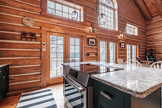 kitchen with stainless steel range with electric stovetop, rustic walls, and french doors