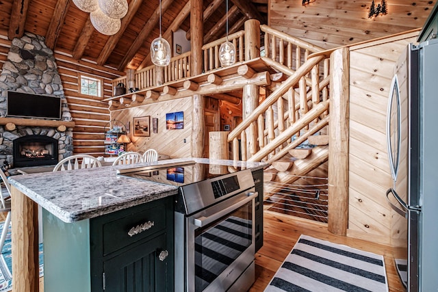 kitchen with appliances with stainless steel finishes, wood ceiling, beamed ceiling, rustic walls, and hardwood / wood-style flooring