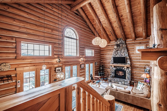 unfurnished living room featuring wood ceiling, high vaulted ceiling, log walls, and beamed ceiling