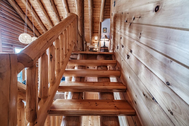 staircase featuring wooden ceiling, wood walls, and beamed ceiling