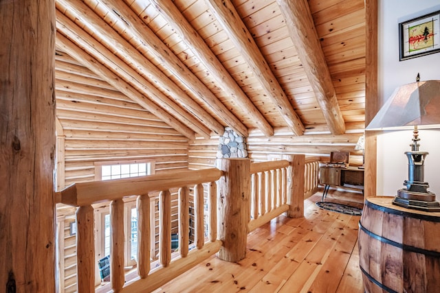 additional living space with wood ceiling, beamed ceiling, rustic walls, and light hardwood / wood-style flooring