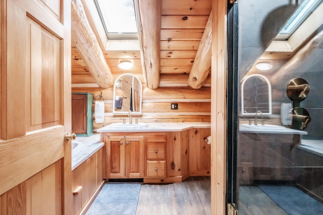 bathroom featuring hardwood / wood-style floors, a skylight, and wood ceiling