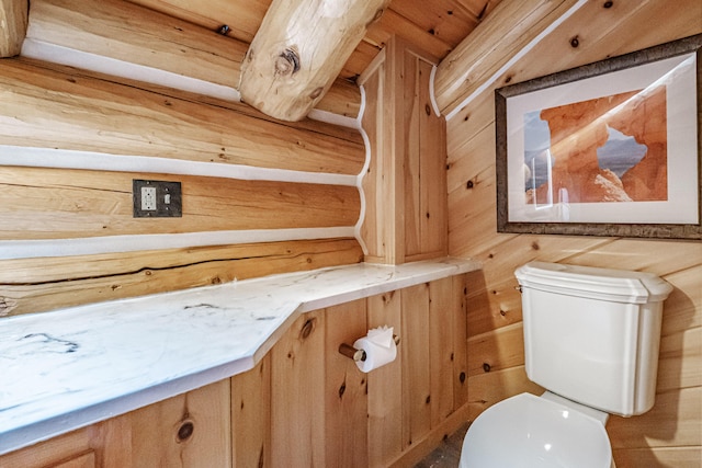 bathroom with toilet and wooden walls