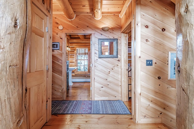 doorway to outside featuring wooden ceiling, hardwood / wood-style floors, wooden walls, and beamed ceiling