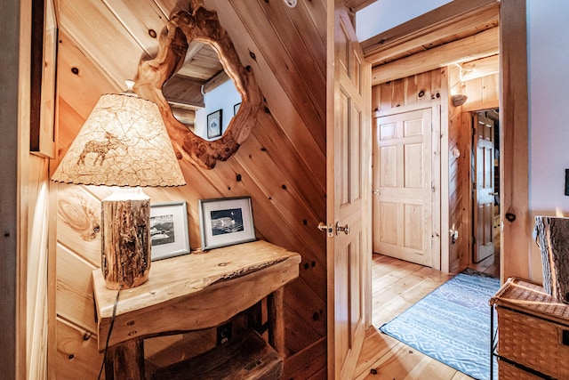 corridor featuring light hardwood / wood-style flooring and wood walls