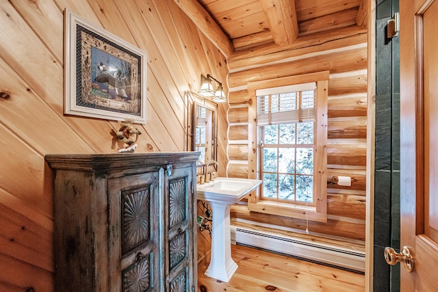 bathroom with hardwood / wood-style floors, wooden ceiling, baseboard heating, rustic walls, and beamed ceiling